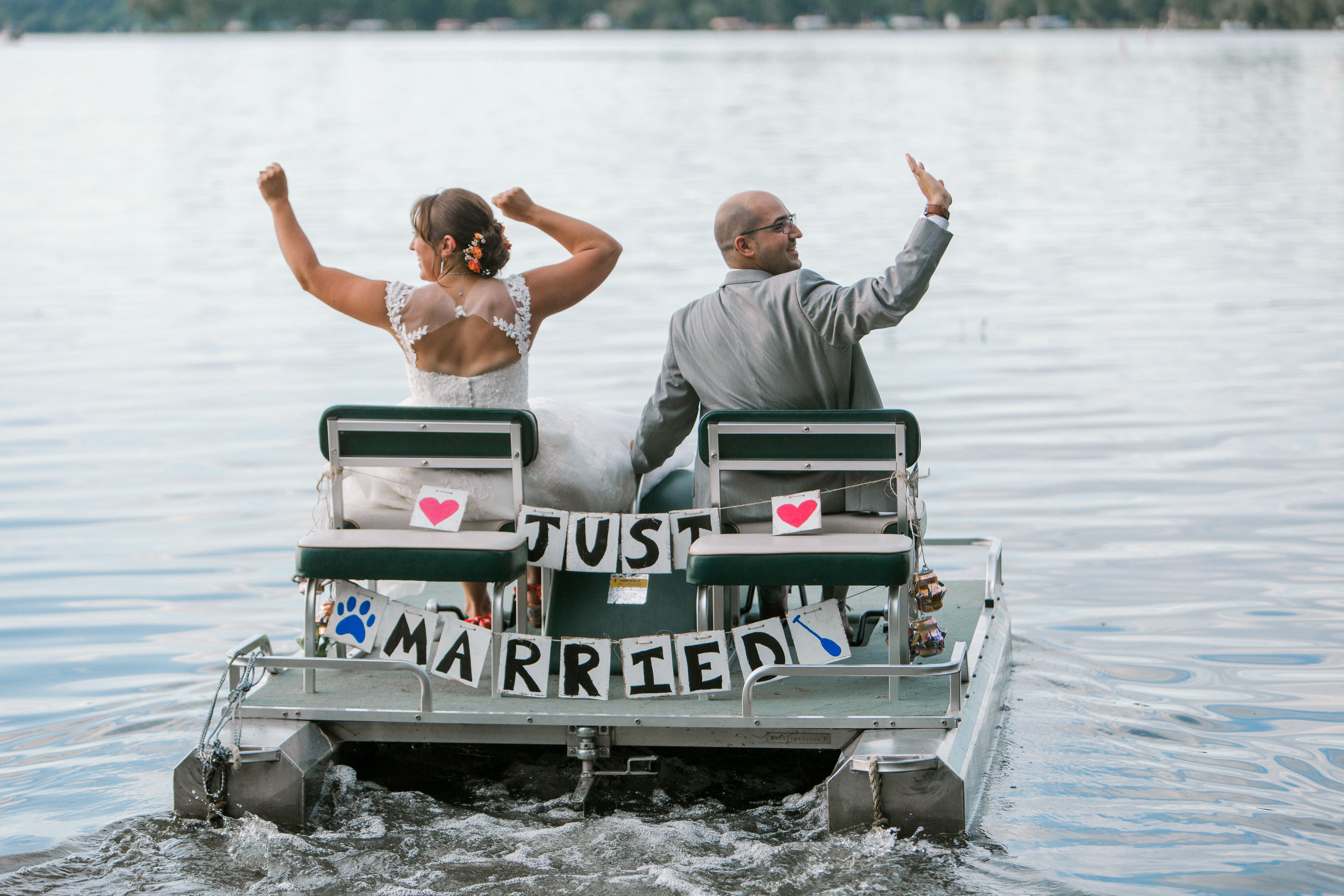 Bride and groom riding paddle boat with just married sign