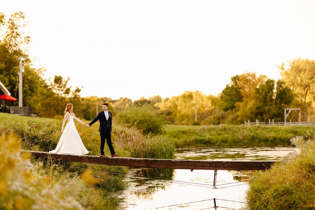 bride and groom sunset walk across bridge