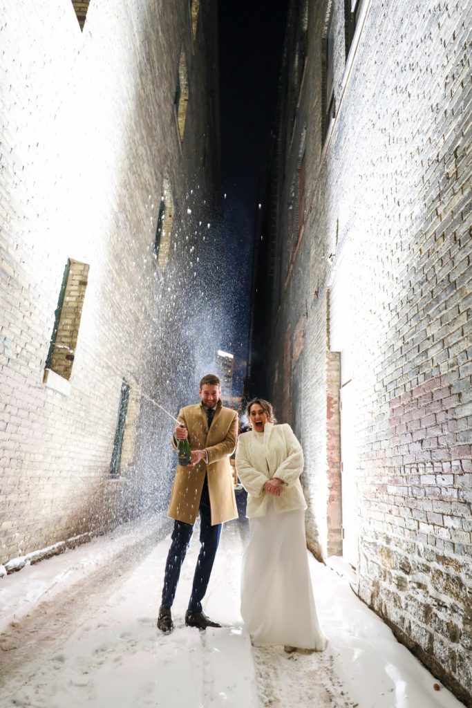 popping champagne outdoor winter wedding photo