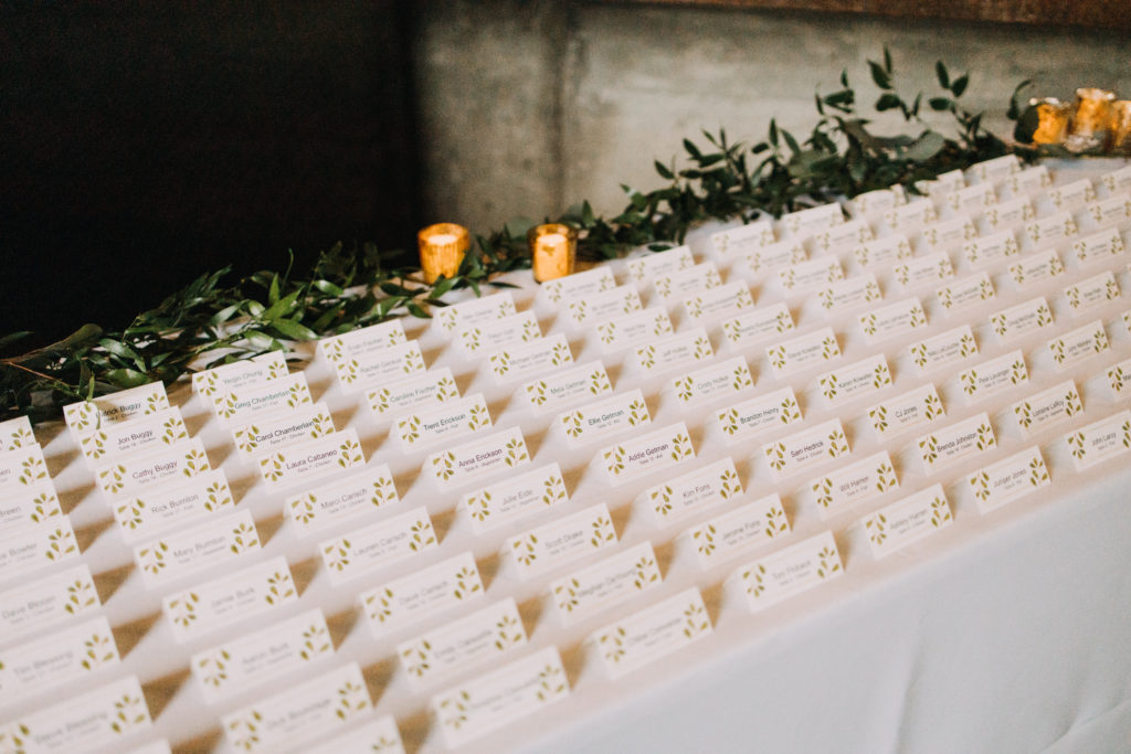 escort card table with gold votives and greens