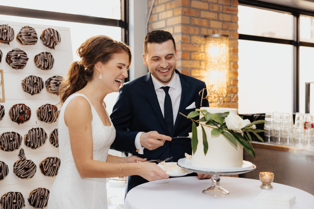 bride and groom cut cake at Lumber Exchange venue