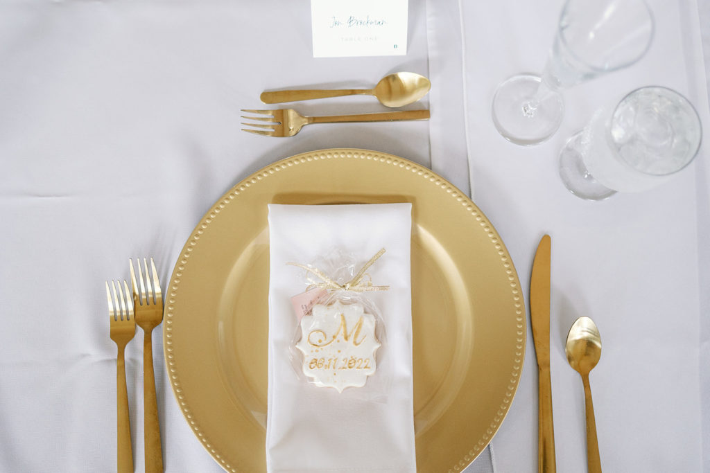 gold flatware at wedding reception with custom cookie