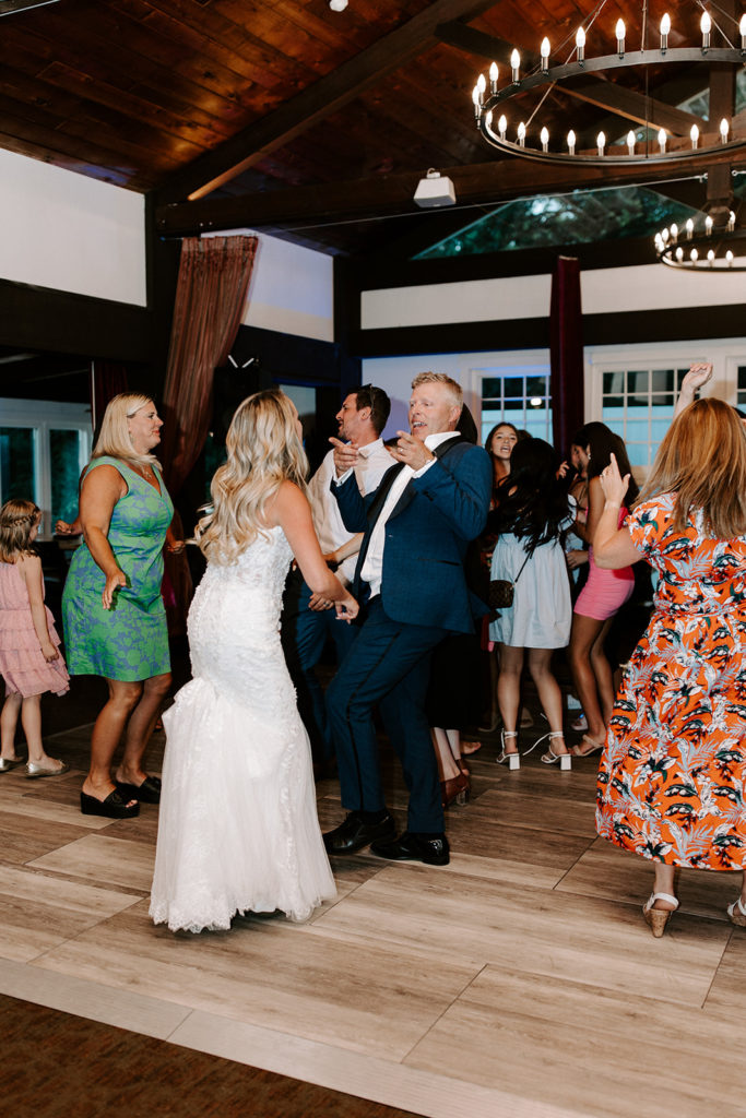 bride and groom on dance floor with guests at Cast & Cru wedding