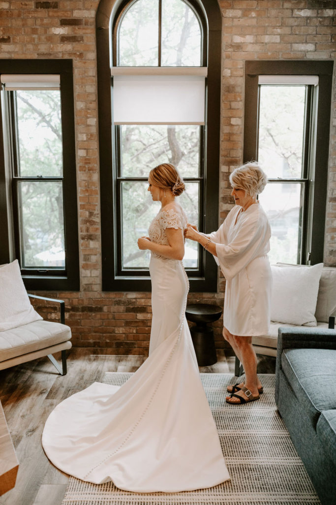 bride-getting-dressed-with-MOB-brick-hotel-room