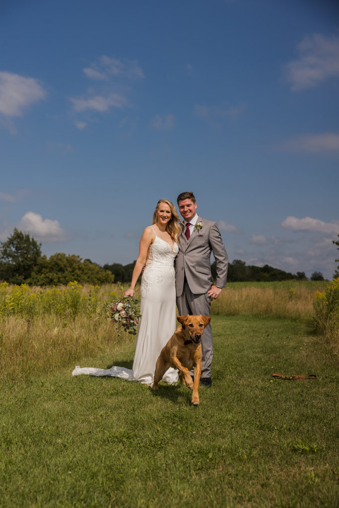bride-groom-portrait-with-dog-running-at-camera