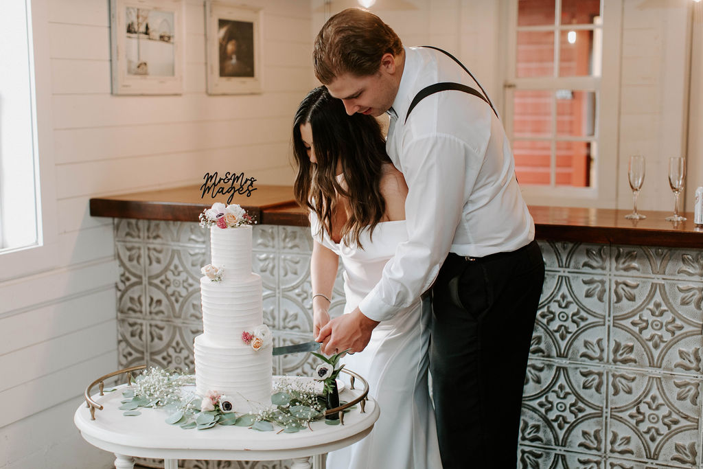 bride-groom-cutting-tiered-wedding-cake-redeemed-farm