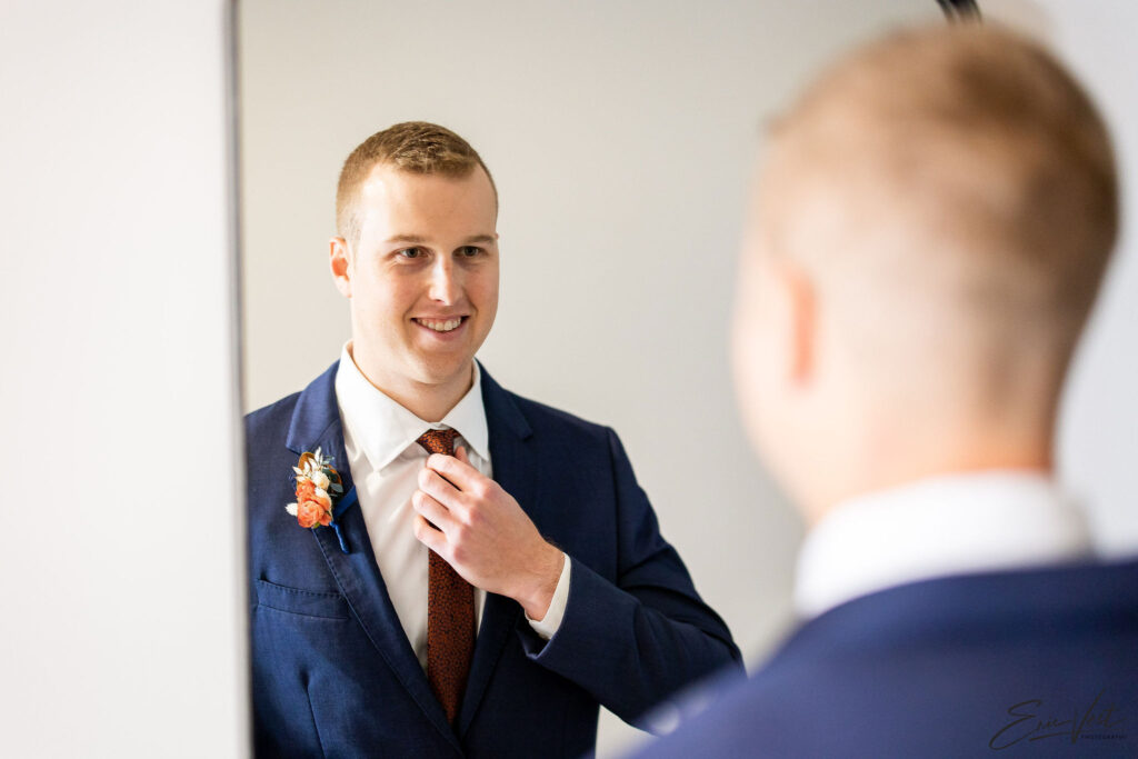 groom-getting-ready-reflection-mirror-blue-suit
