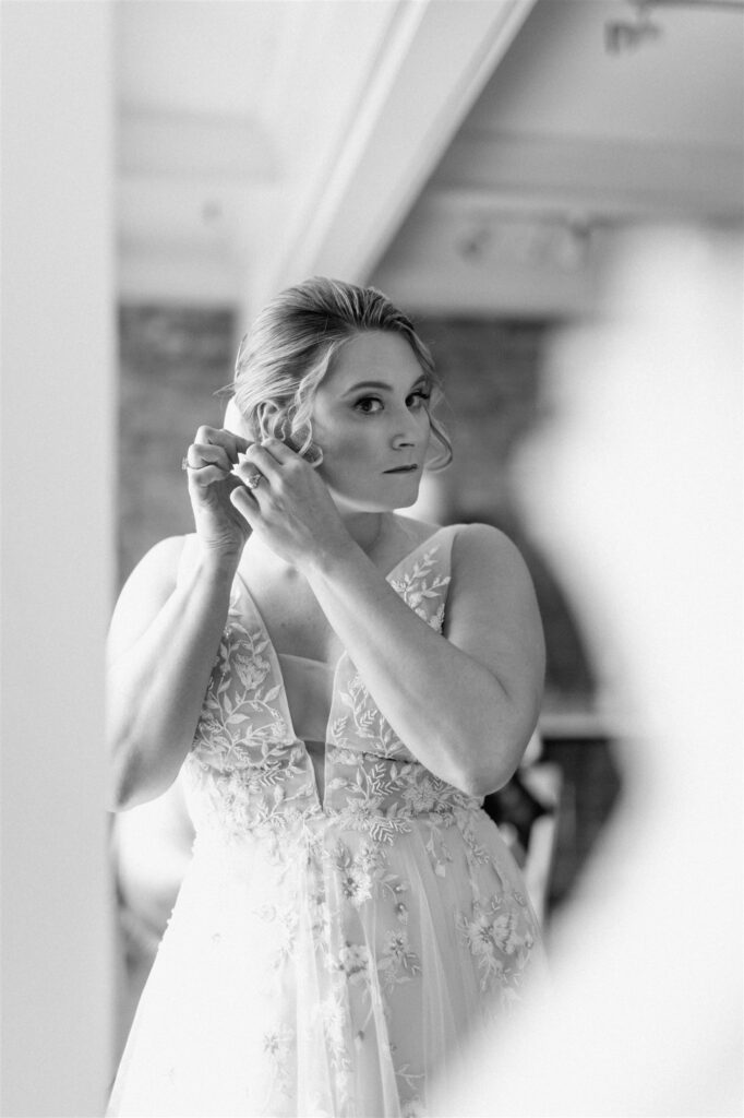 bride getting ready putting on earrings