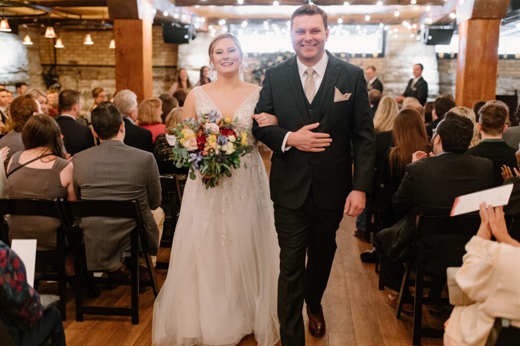 bride and groom celebratory recessional at colorful st Anthony main wedding
