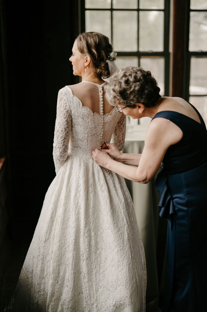 bride getting ready putting on vintage wedding dress