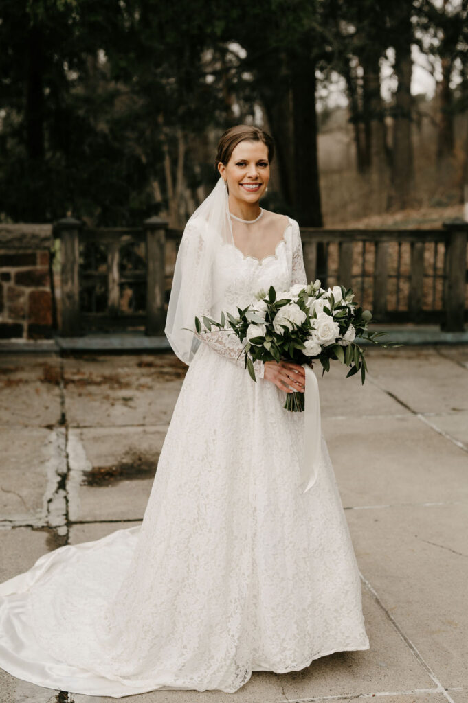 bride portrait with white floral bouquet and greenery