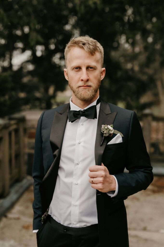 groom portrait in black tux with black bowtie