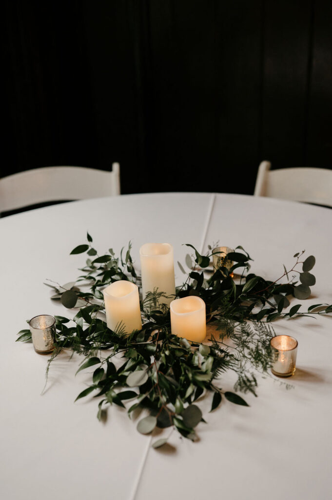 simple wedding reception table decor with candles and greenery