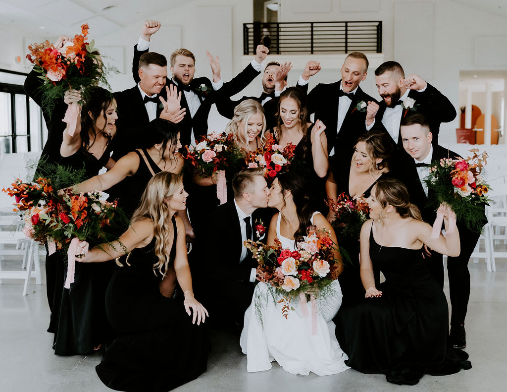 wedding party group photo wearing black attire with colorful florals