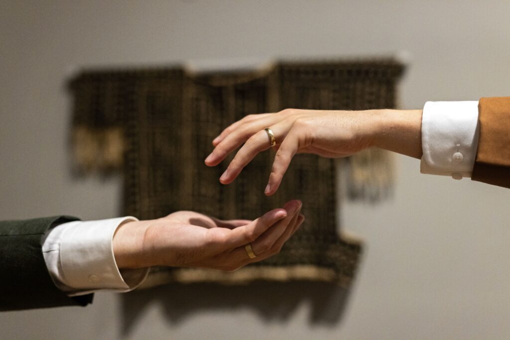 grooms hands reaching for one another in artsy wedding photo