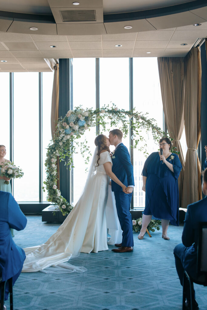 ceremony kiss at downtown Minneapolis wedding in Windows at Marquette