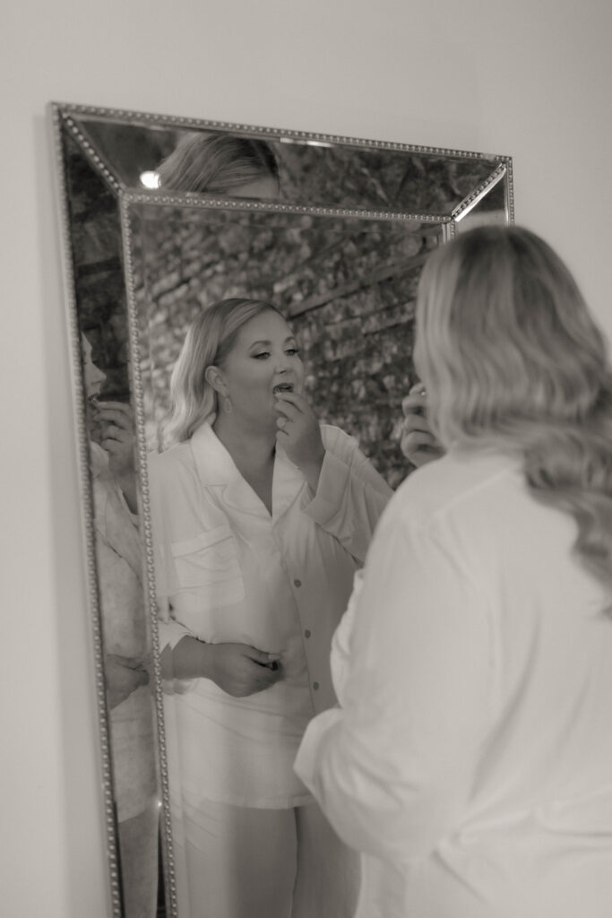 bride doing makeup in mirror