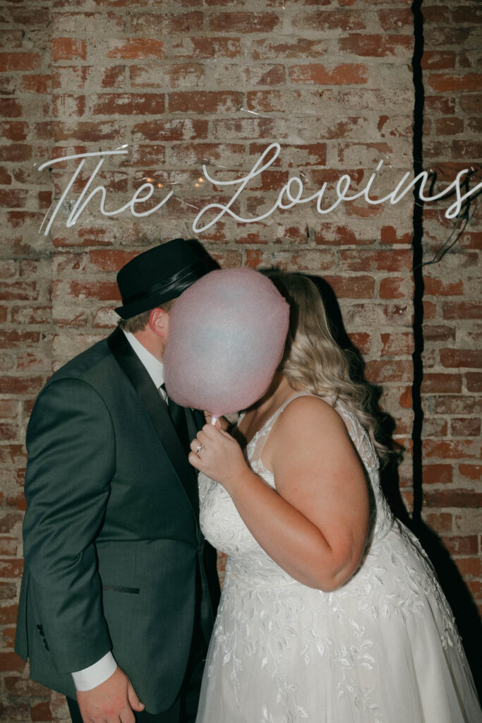 couple kissing behind cotton candy