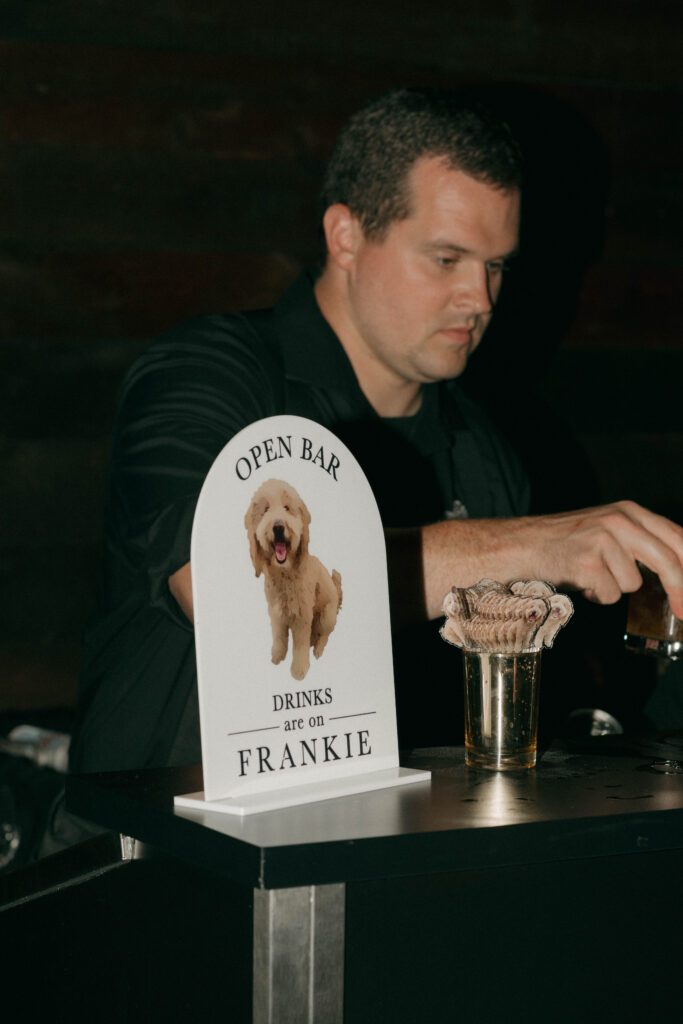 open bar sign with couple's dog
