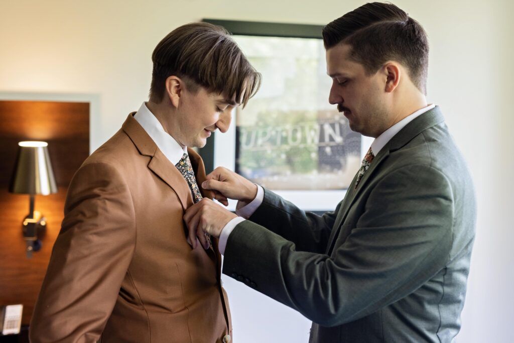 grooms getting ready tying ties wedding morning