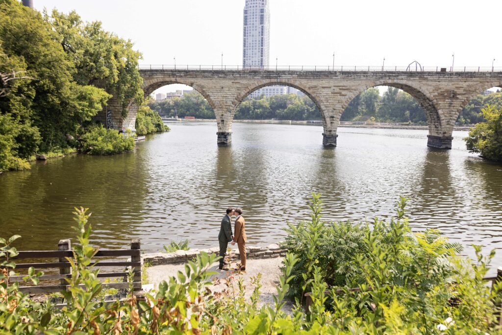 grooms wedding portrait at stone arch bridge