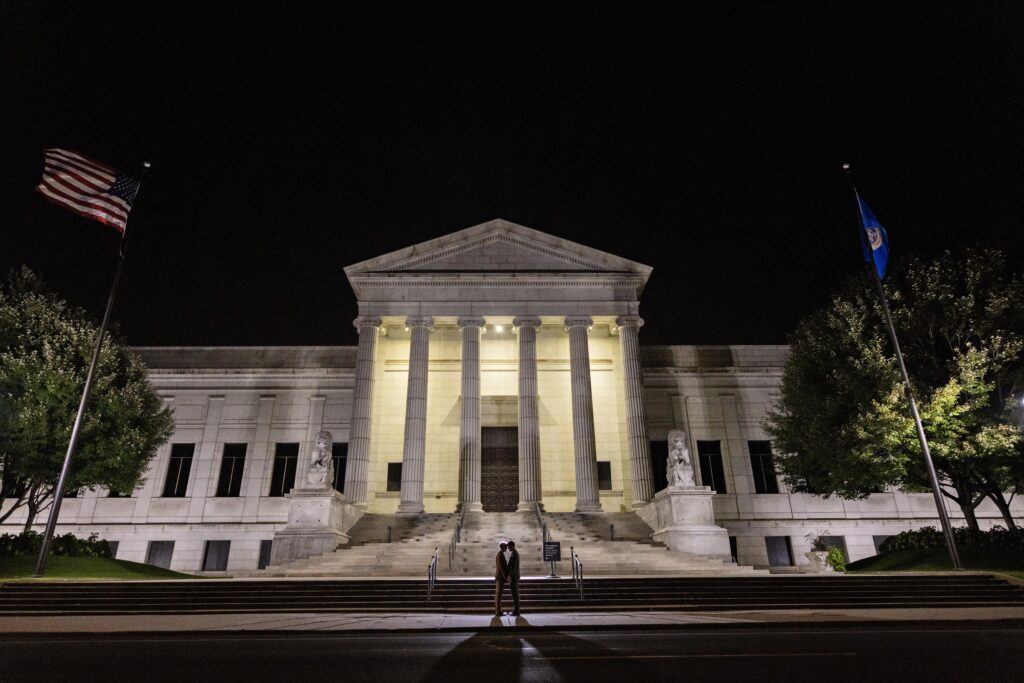 backlit portrait of grooms in front of Minneapolis Institute of Art