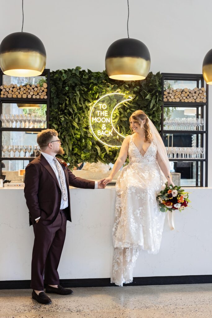 bride and groom bar portrait with LED sign 