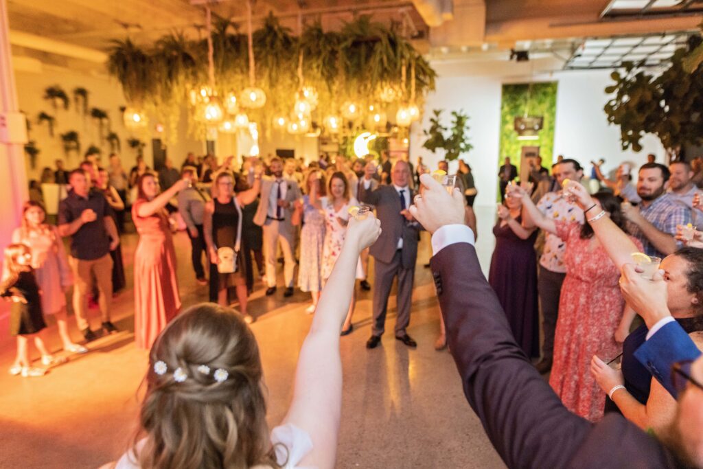 couple cheers toast with guests at woodland fairy wedding