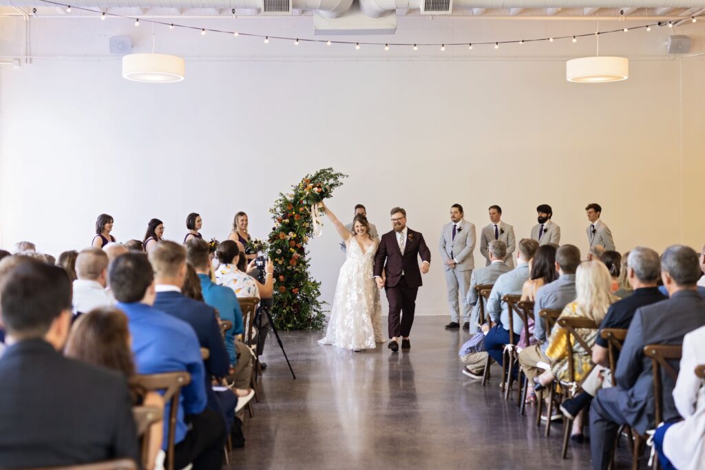 bride and groom celebrate recessional at Urban Daisy