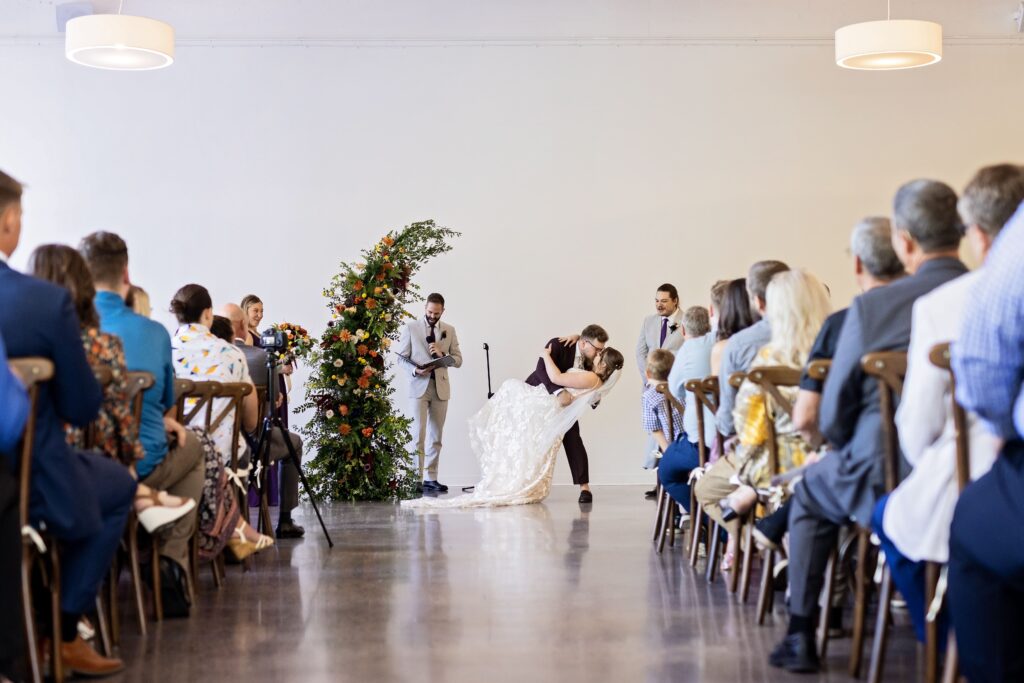 bride and groom dip kiss at ceremony 