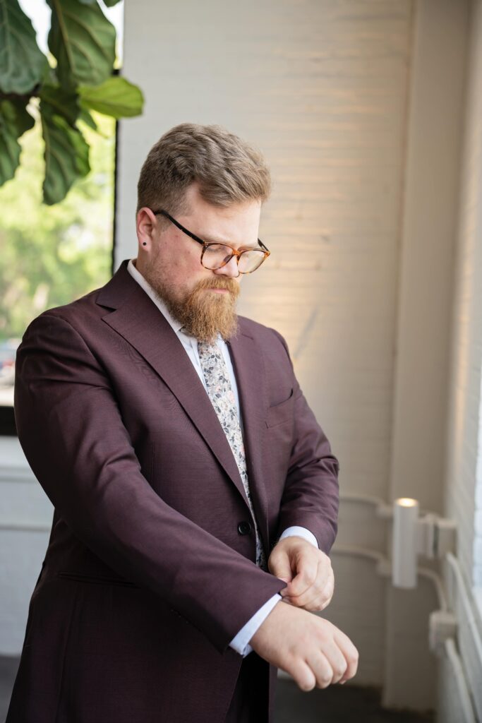 groom in maroon suit and floral tie