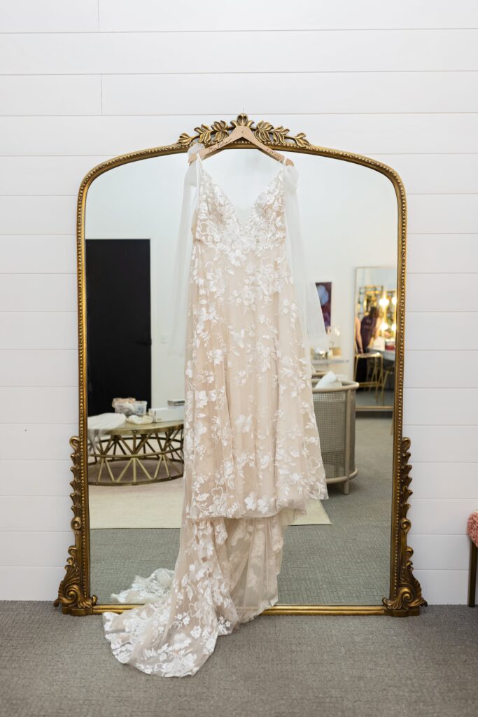 Wedding dress hanging on mirror at Urban Daisy