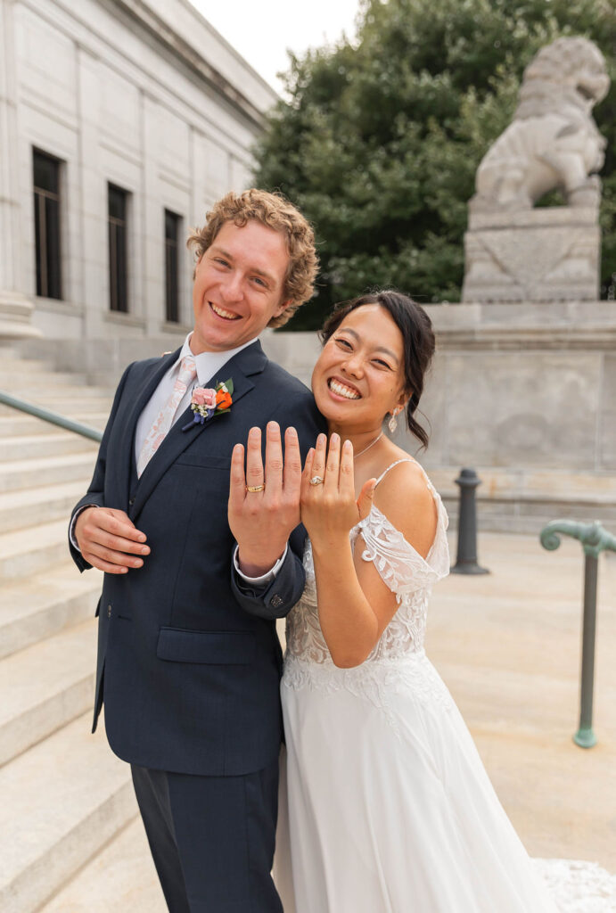 bride and groom showing off rings portrait