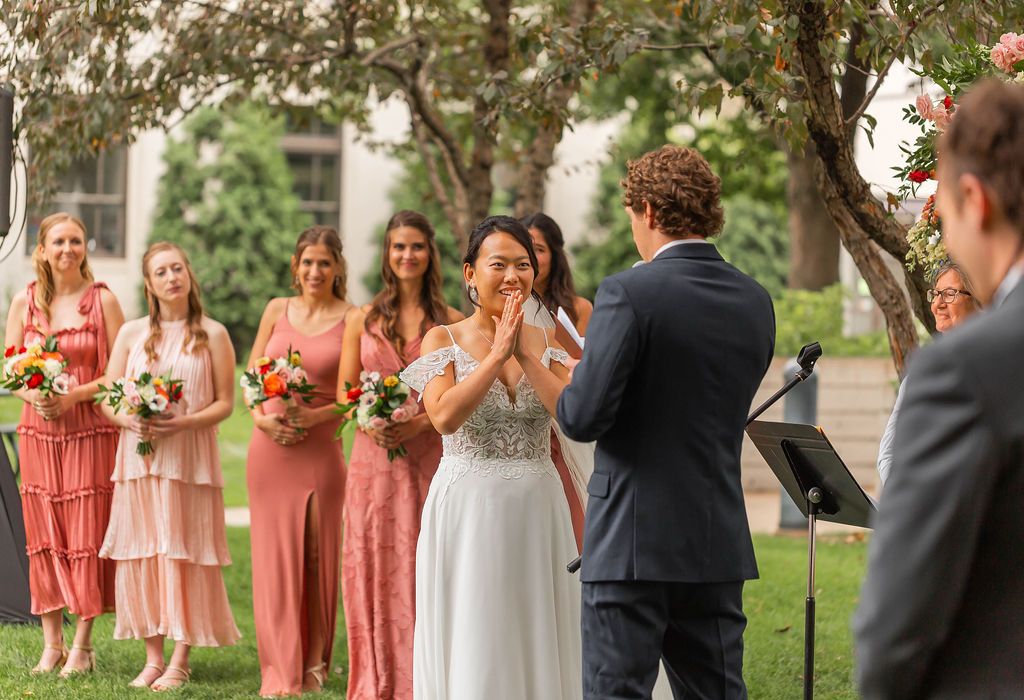 bride reaction to groom vows in outdoor ceremony