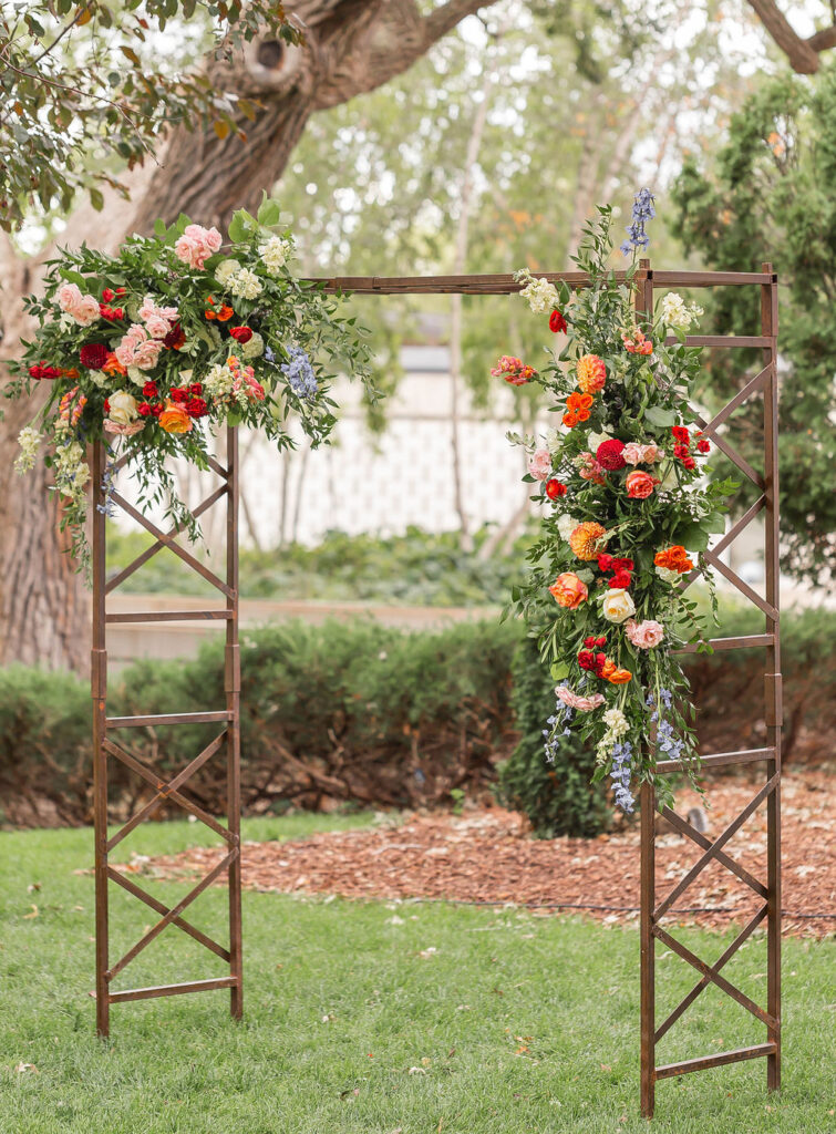 colorful floral installments on outdoor wedding ceremony arch