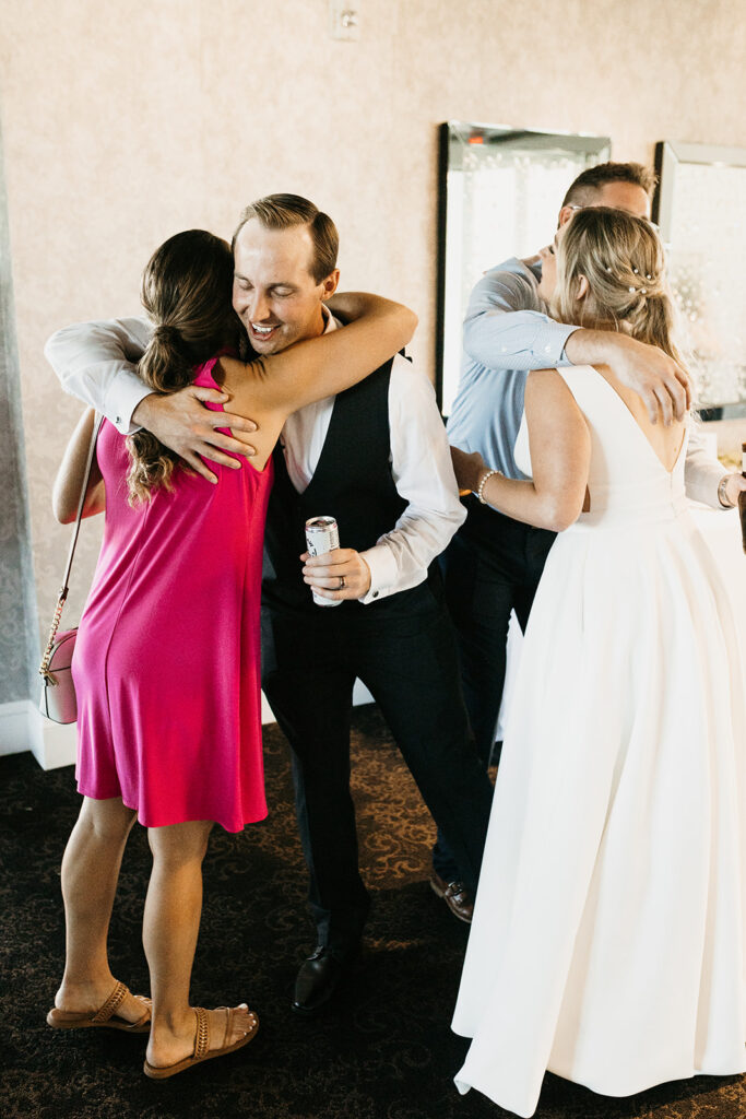 bride and groom hugging guests during cocktail hour