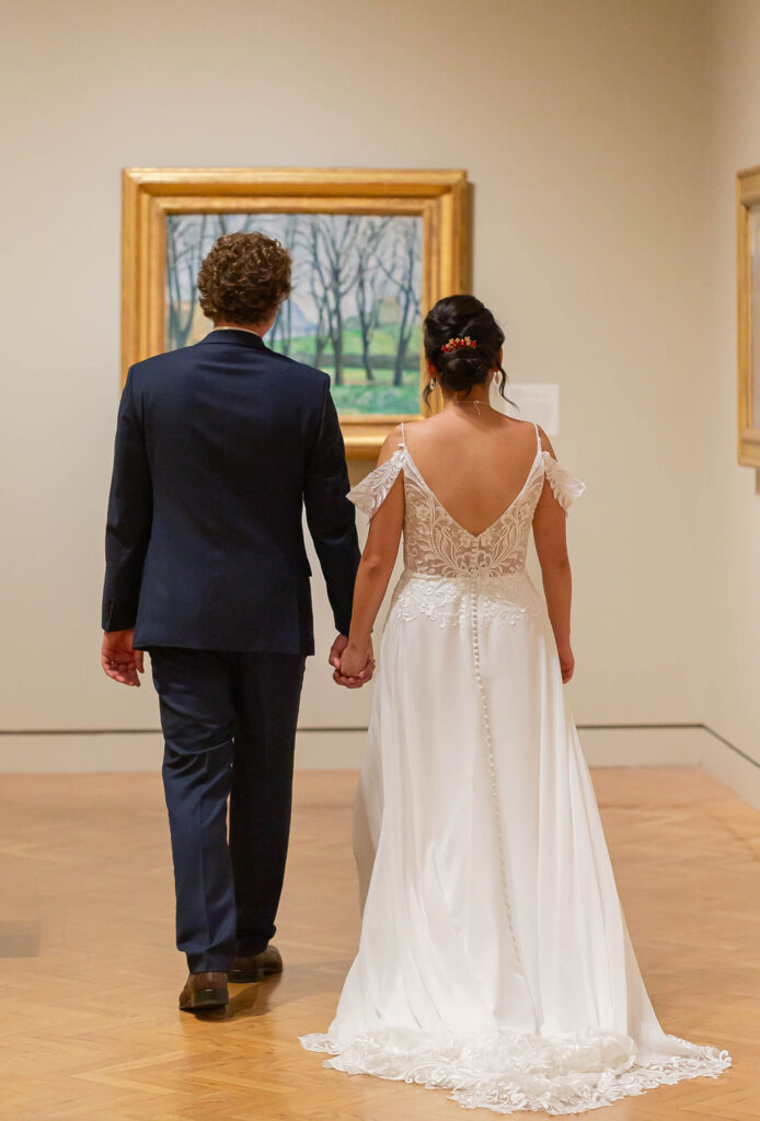 bride and groom admiring art in museum wedding