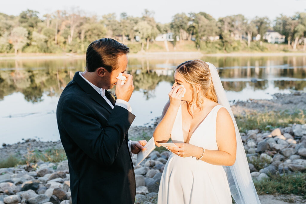 bride and groom drying tears after reading personal vows