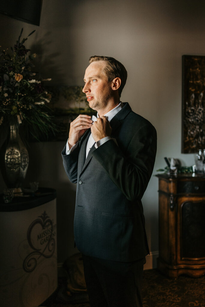 Groom getting ready tying bowtie