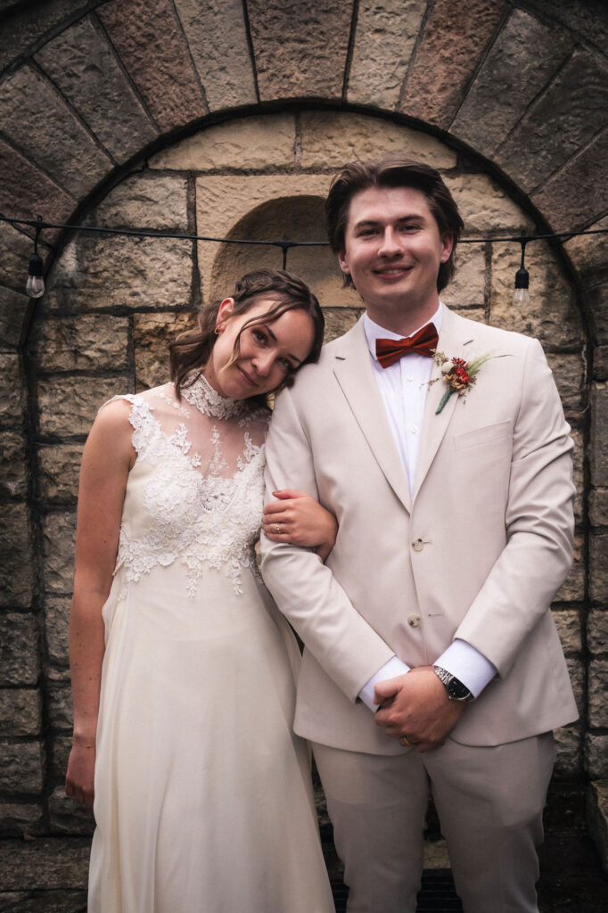 bride cuddling groom's arm in wedding portrait