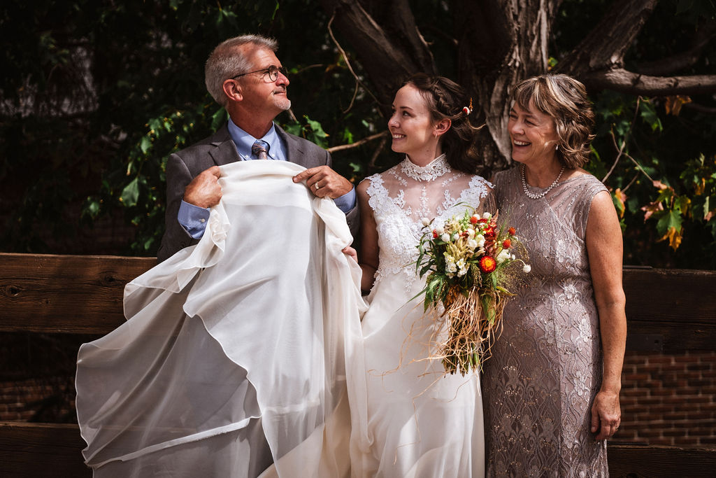 funny wedding photo of dad making bride and mom laugh