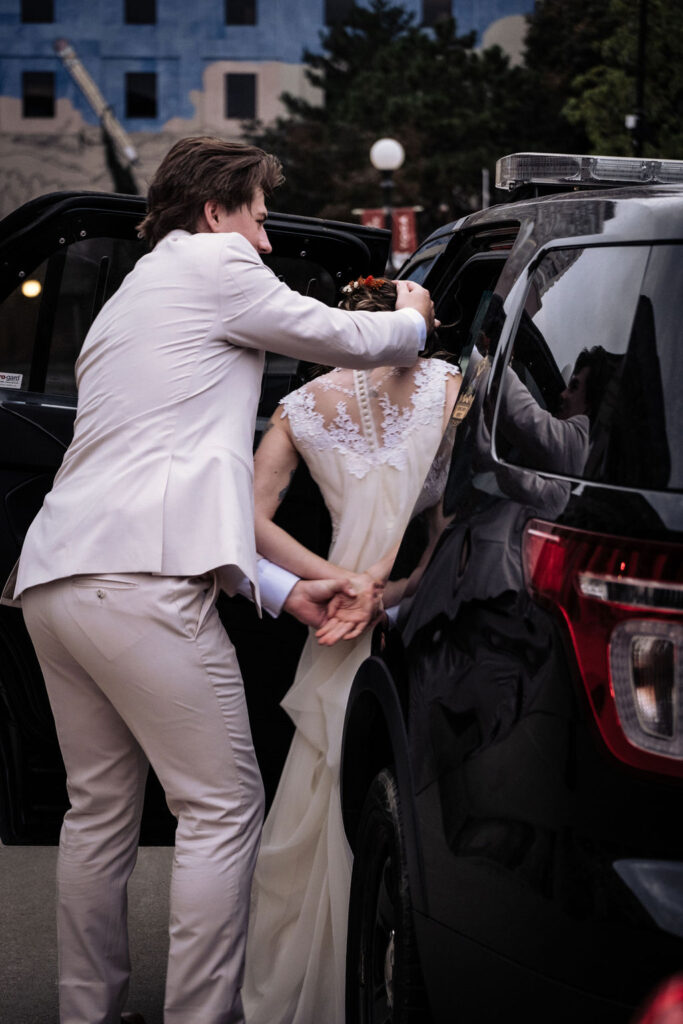 funny wedding portrait of groom arresting bride