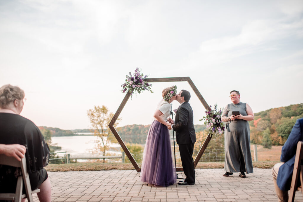 Bride and groom kiss for outdoor ceremony at Gale Woods Farm wedding 