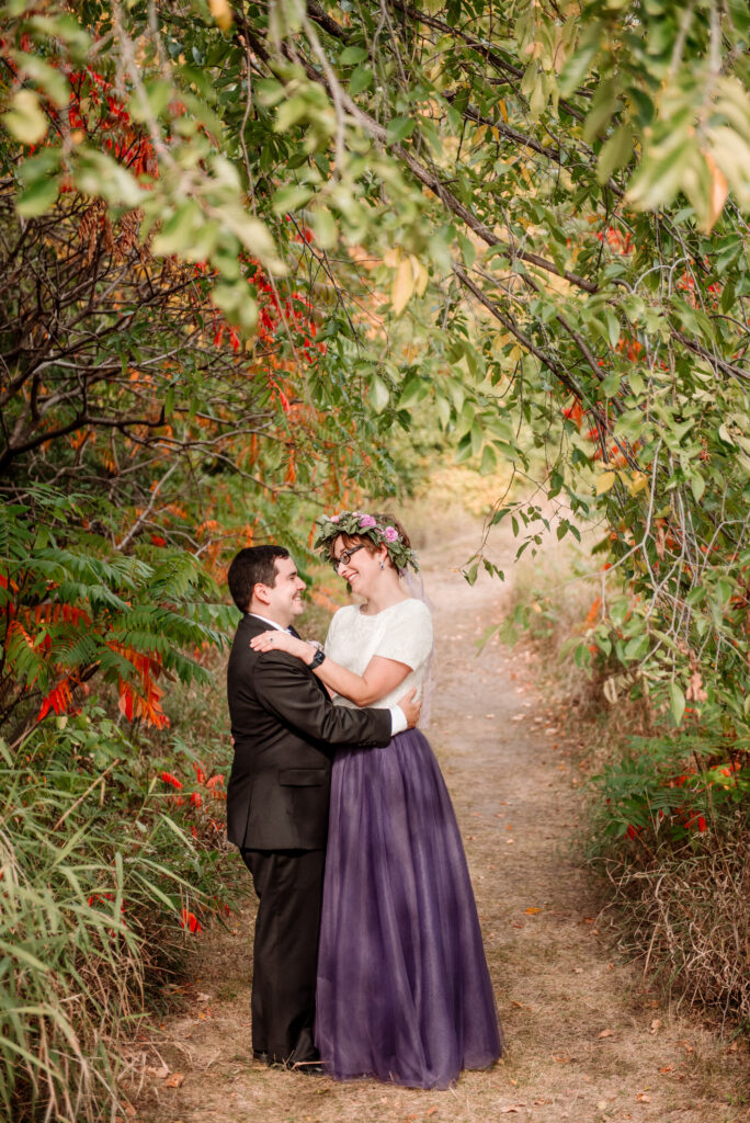 Bride and groom portrait with fall leaves and purple dress