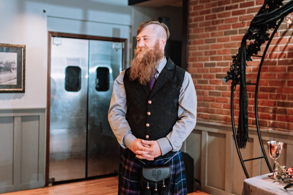 groom smiling at bride entering ceremony