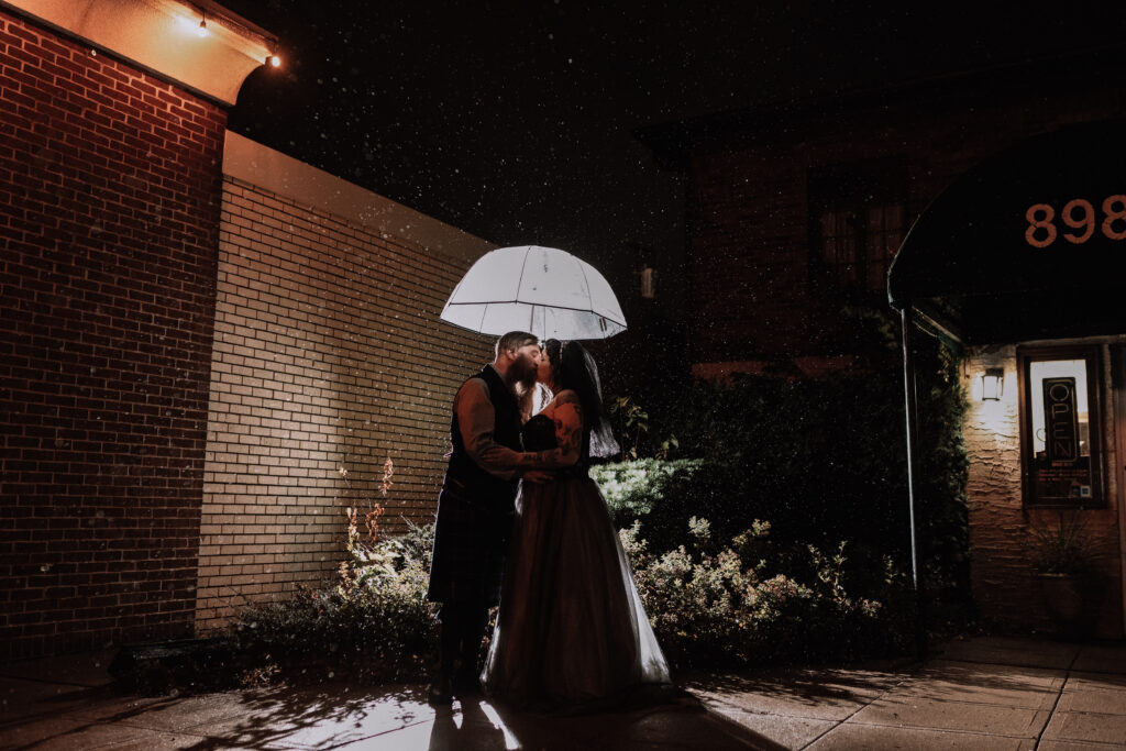 spooky wedding bride and groom night portrait in the rain with umbrella