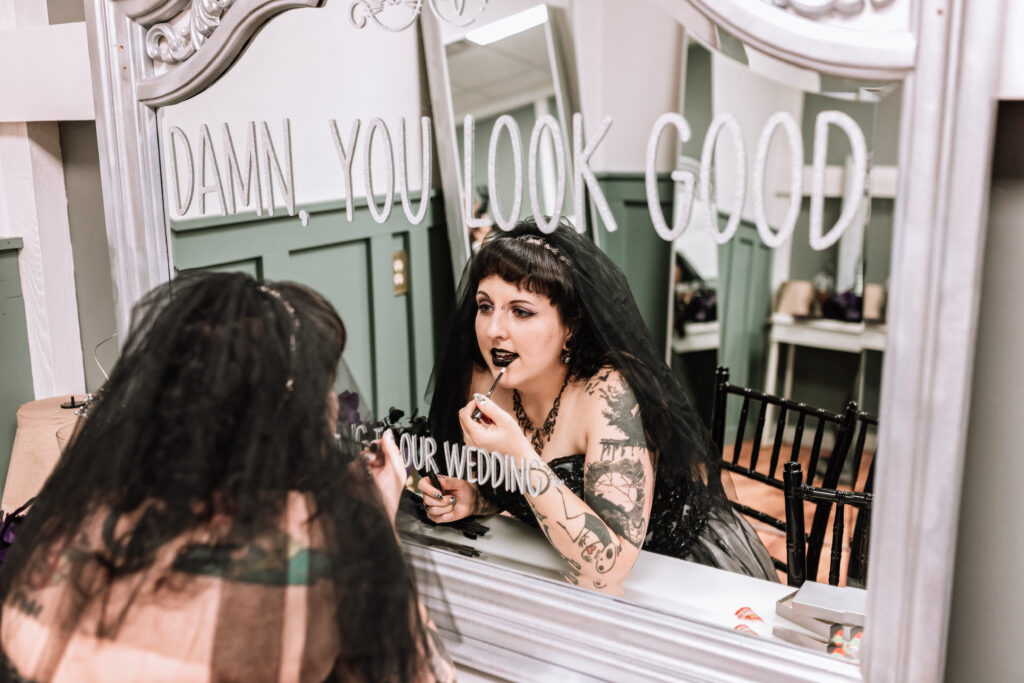 spooky bride getting ready putting on black lipstick