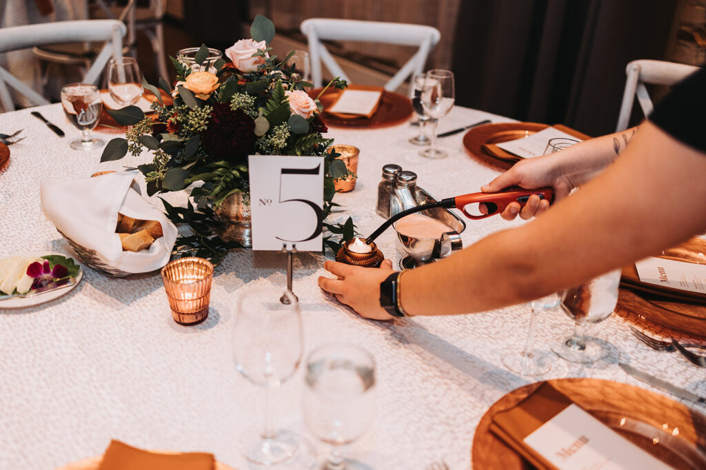 Wedding planner lighting candles for wedding reception