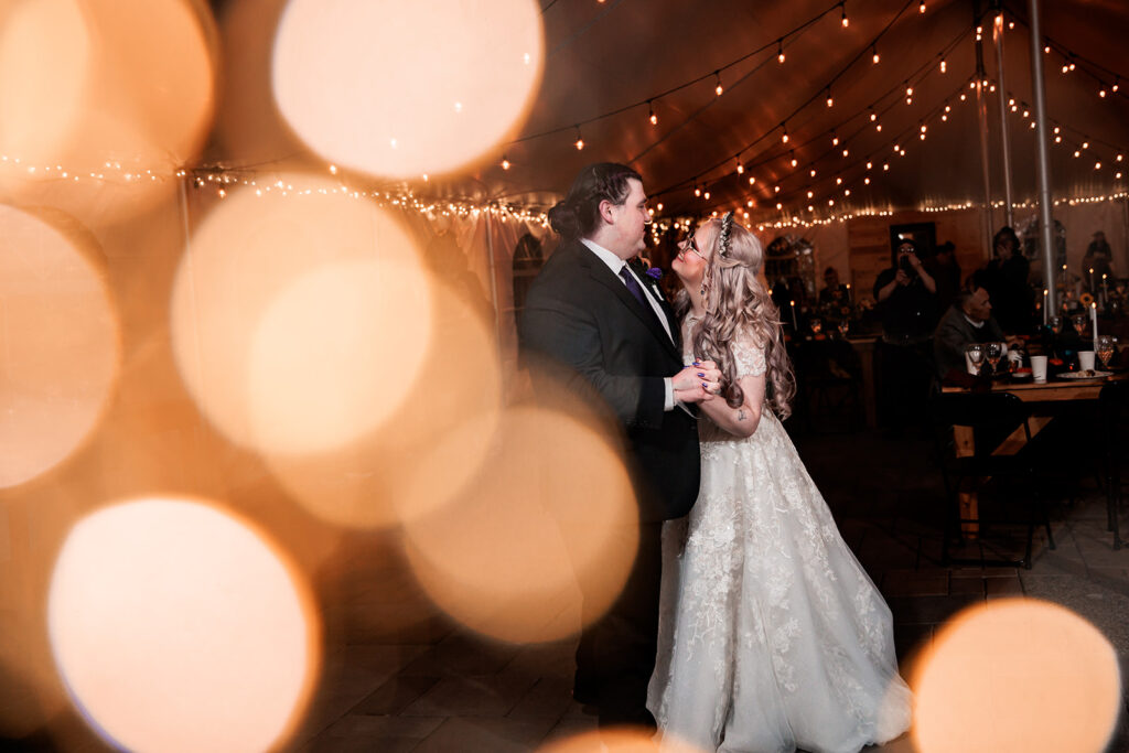 lens flare photo of couple first dance in tent wedding reception