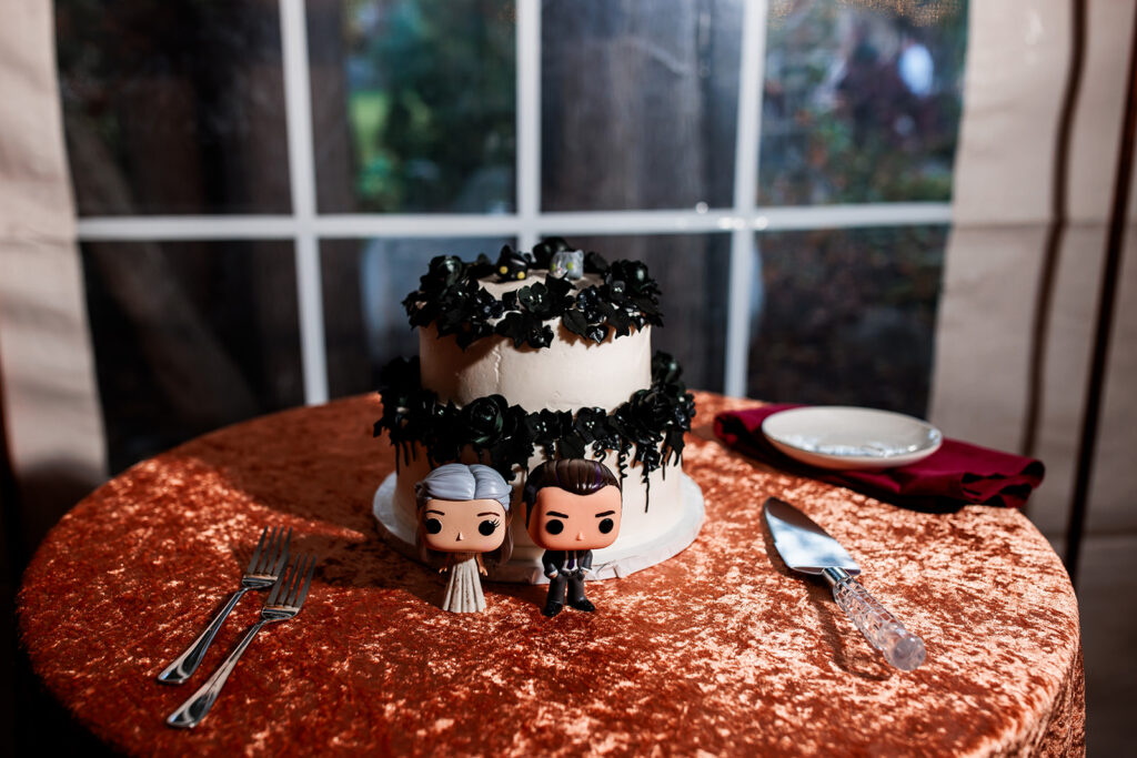 two tiered black and white wedding cake with custom funko pop decorations